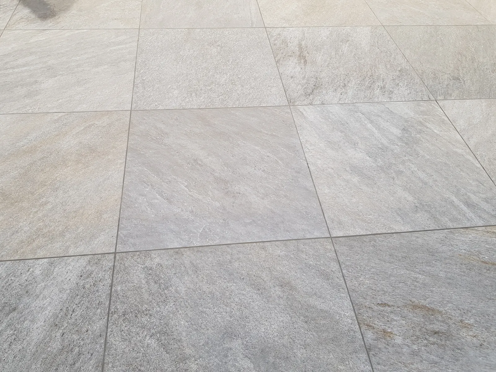 Détail des carreaux et des joints d'une terrasse en grès cérame clair