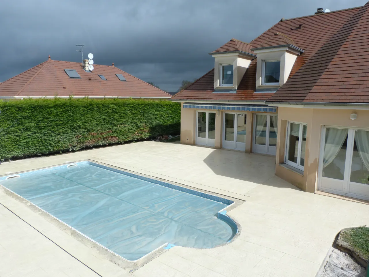 Plage de piscine claire devant une maison à lucarnes