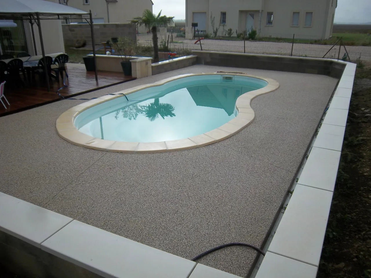 Plage de piscine en béton désactivé autour d'un bassin