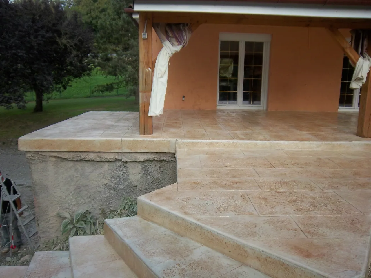 Terrasse surélevée en béton imprimé et départ de l'escalier
