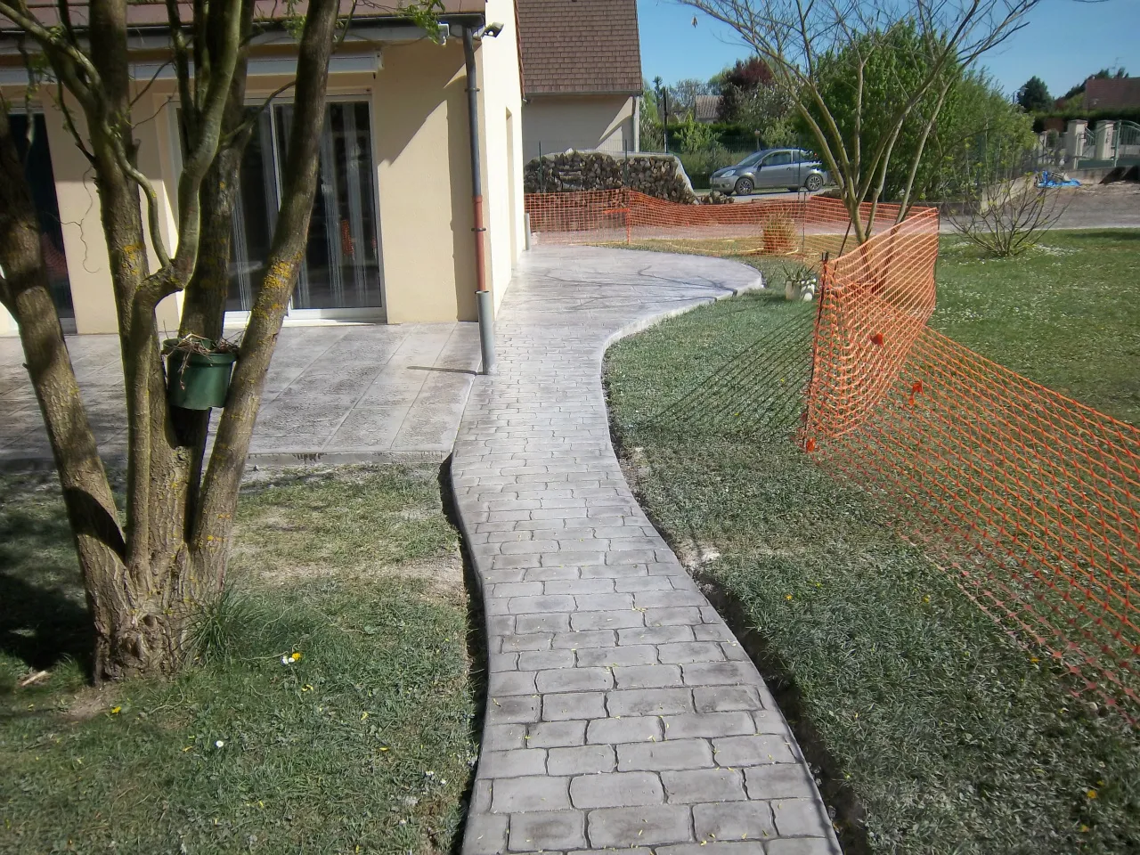 Allée sinueuse en béton imprimé façon pavés